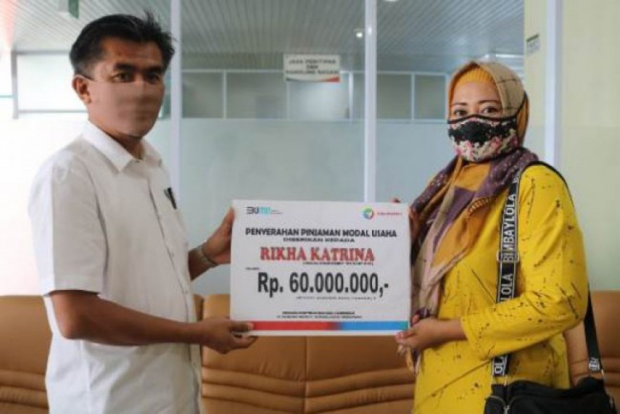 General Manager Pelindo 1 Cabang Tanjungpinang Yusrizal menyerahkan bantuan dana kemitraan kepada Rikha Katrina yang menekuni usaha sektor perdagangan.